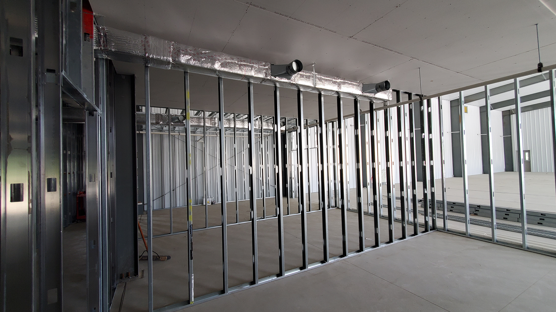 Red Direct pre-engineered steel building being assembled from manufactured structural components