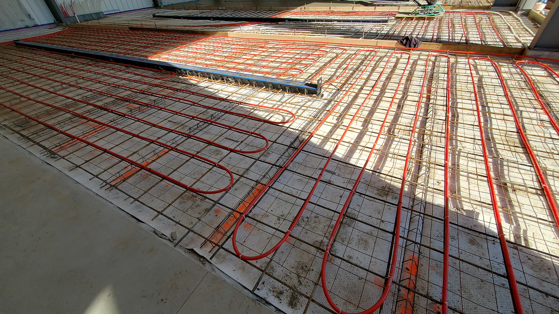 Red Direct steel building supporting renewable energy operations beside a solar panel installation