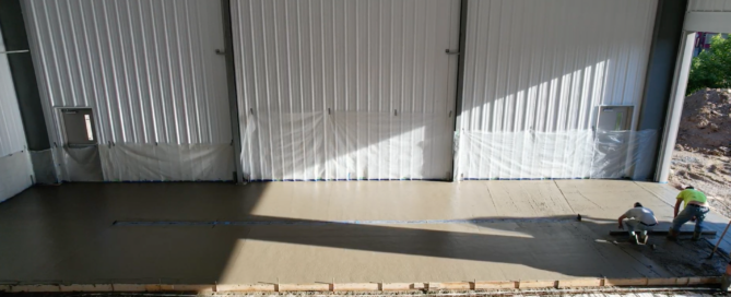 Steel transit maintenance facility with multiple service bays, buses, maintenance equipment, and organized work areas